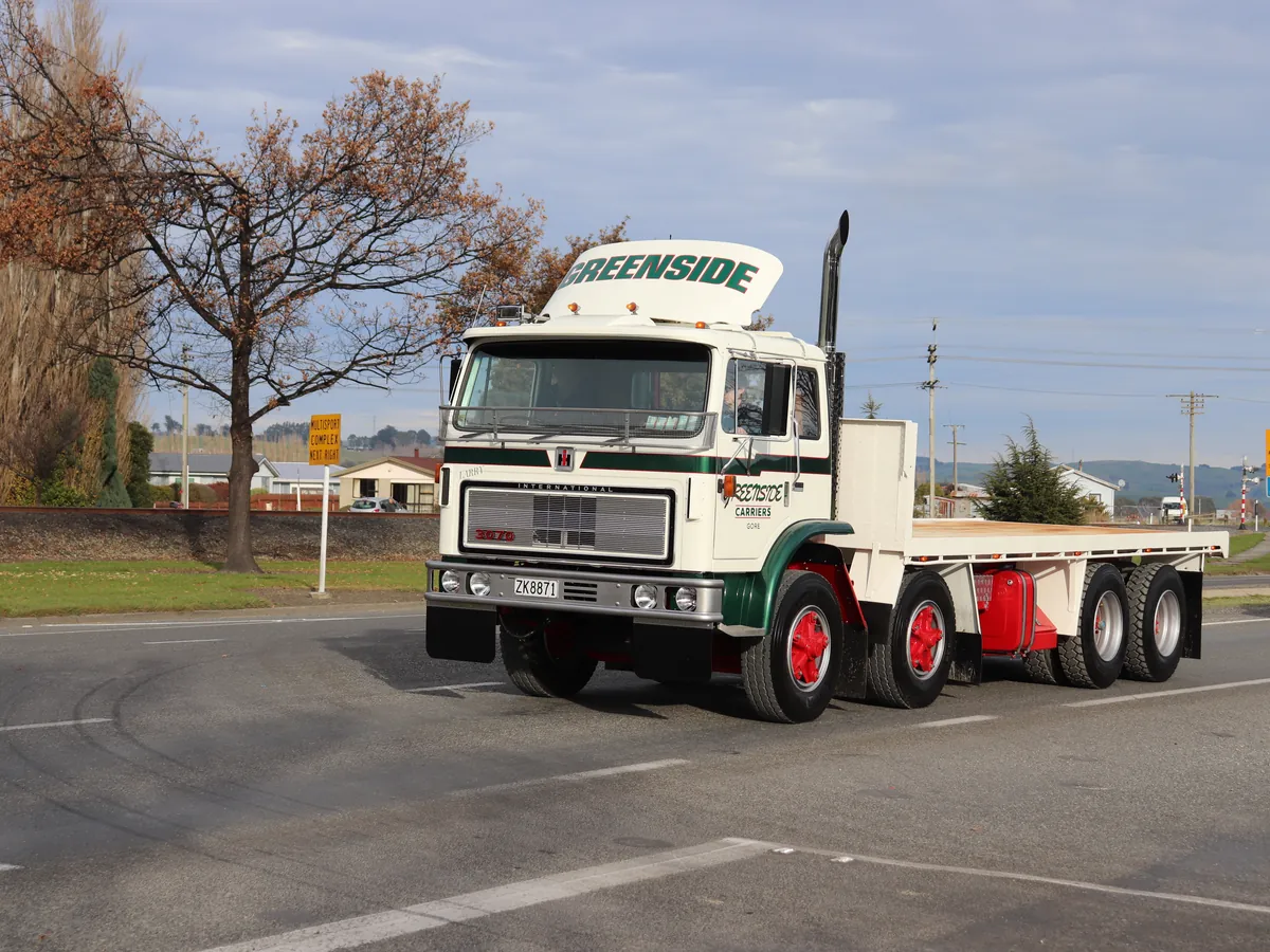 A cream International flatdeck signwritten Greenside turning onto a country road