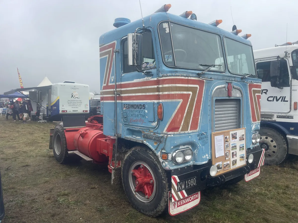 A pale blue Kenworth cab-over signwritten Redmonds, with red chevron stripes down the cab