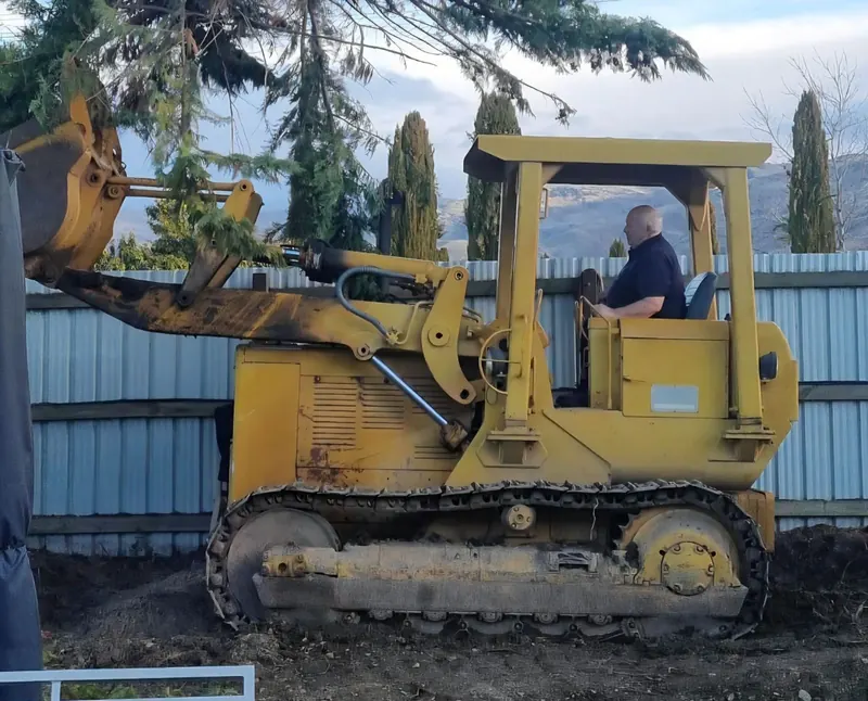 A yellow Caterpillar 951C track loader with its operator