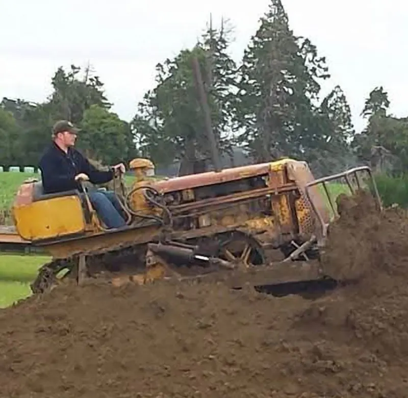 A 1956 Caterpillar D2 crawler pushing a pile of dirt