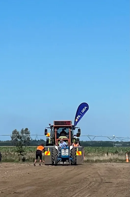 A Fordson Super Major heading down the pull track under a blue sky