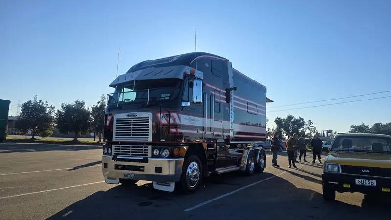 A maroon Freightliner Argosy with a show trailer
