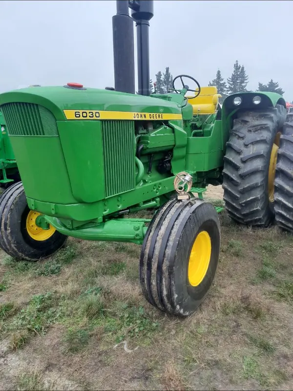 A green John Deere 6030 with yellow wheels