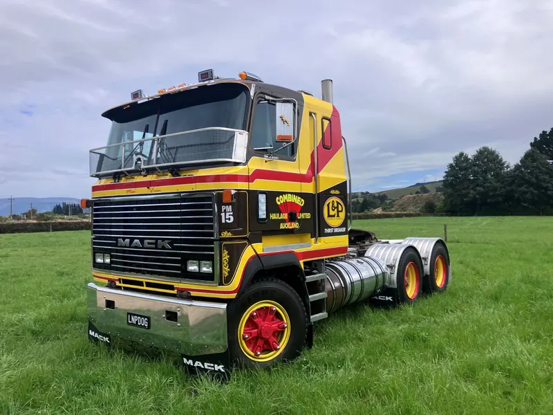 A Mack Ultra-Liner in black, yellow and red livery on grass