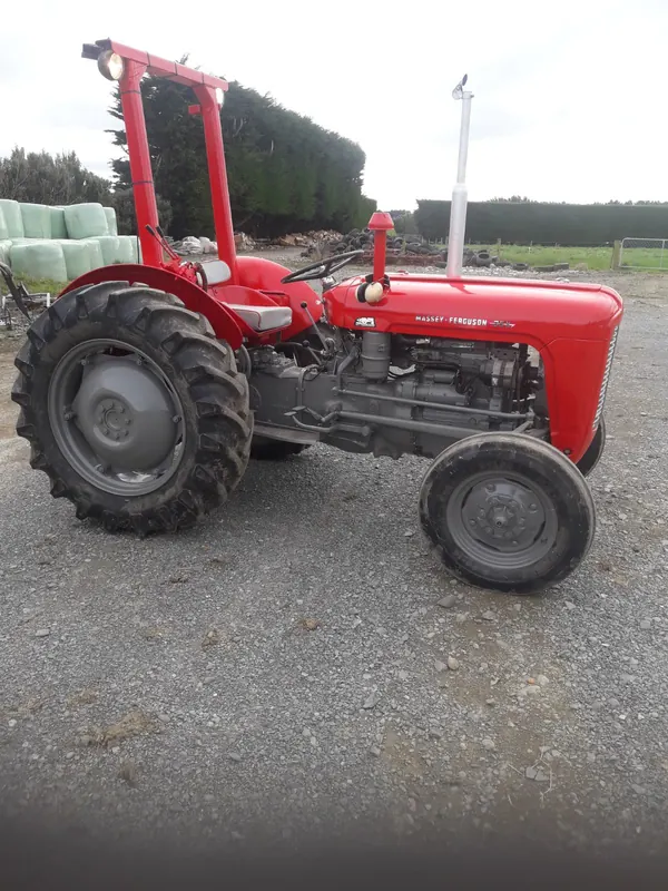 A red Massey Ferguson 35X on a gravel yard