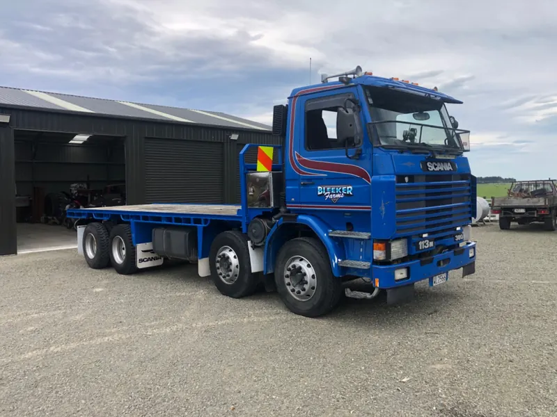 A blue Scania 380 eight wheeler flatdeck
