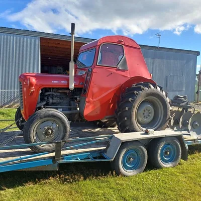 A restored red vintage tractor on a trailer