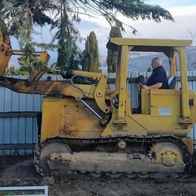 A Caterpillar crawler loader with its operator